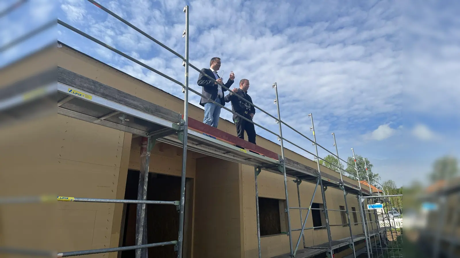 Bürgermeister Torben Busse und Marcel Sander, Geschäftsführer Sander, stiegen für den Richtspruch aufs Dach. (Foto: Julia Sürder)